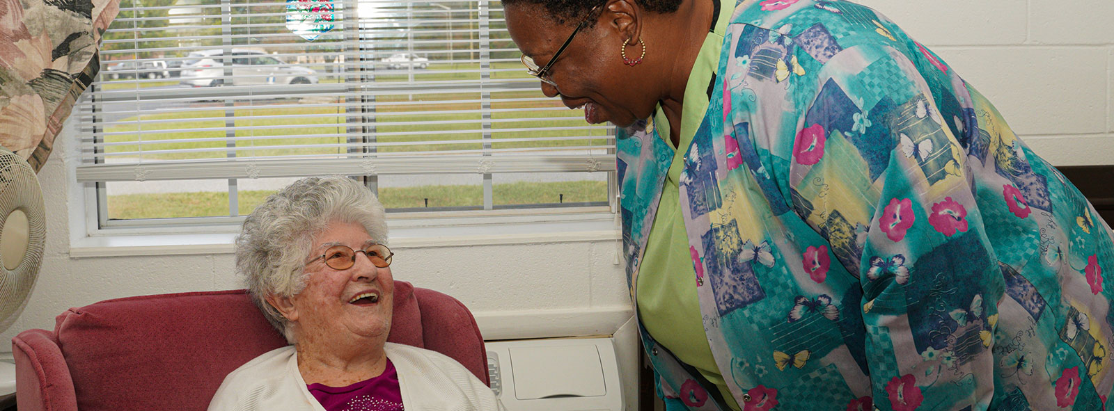 Nurse interacting with patient at skilled nursing facility.